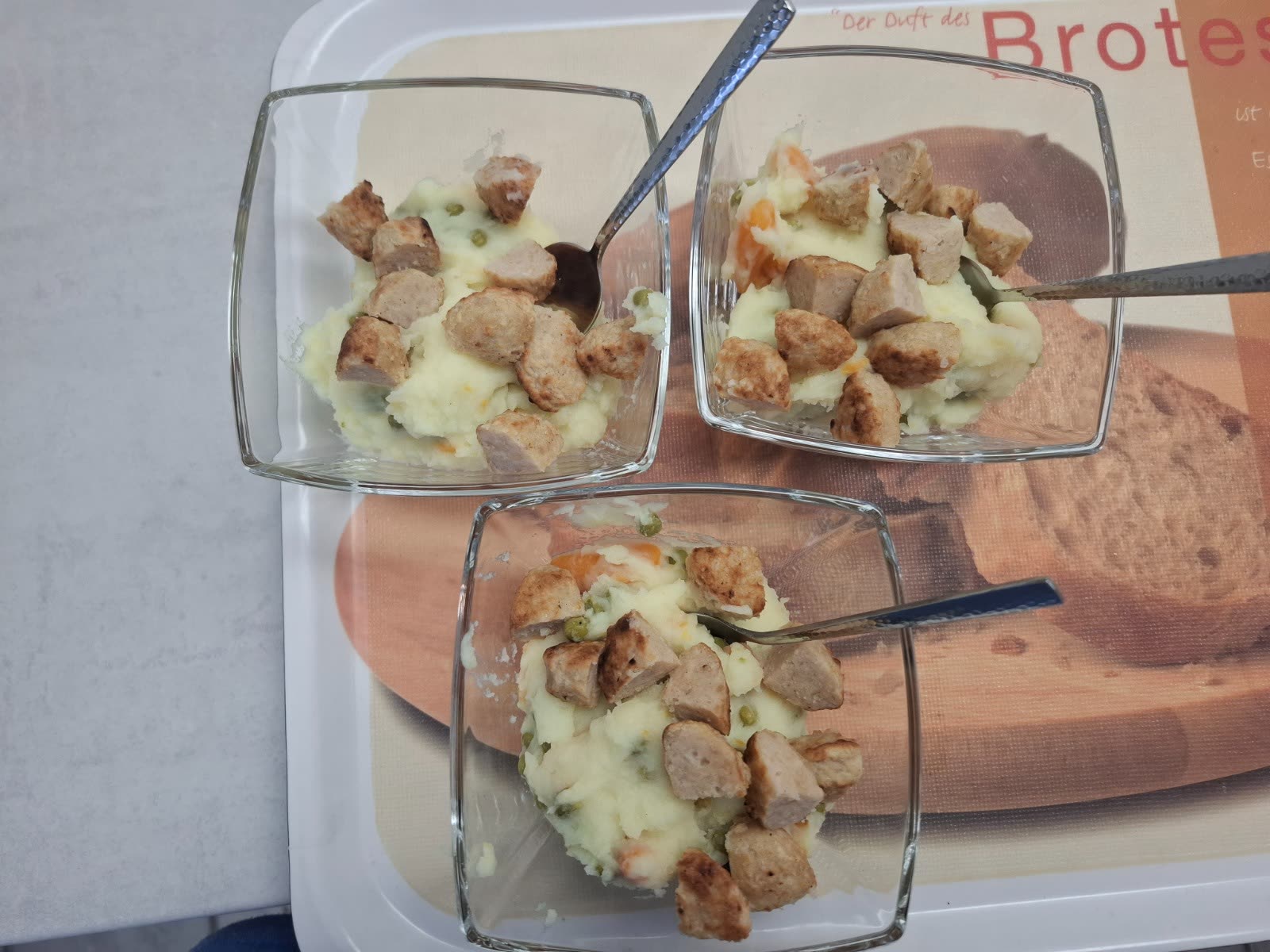Kindgerechte Portionen Kartoffelgemüse mit kleinen Fleischbällchen in Glasschalen