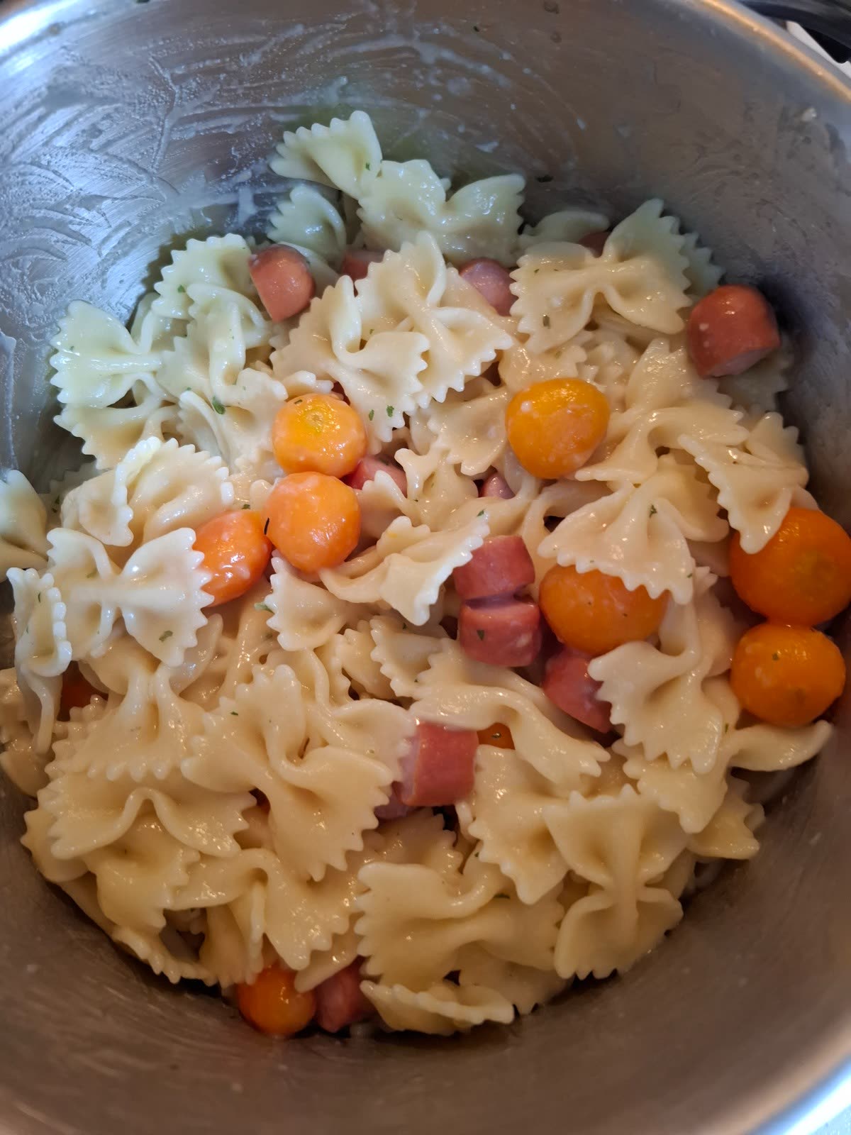 Nudeln mit Möhren und kleinen Würstchenstücken in einem Kochtopf