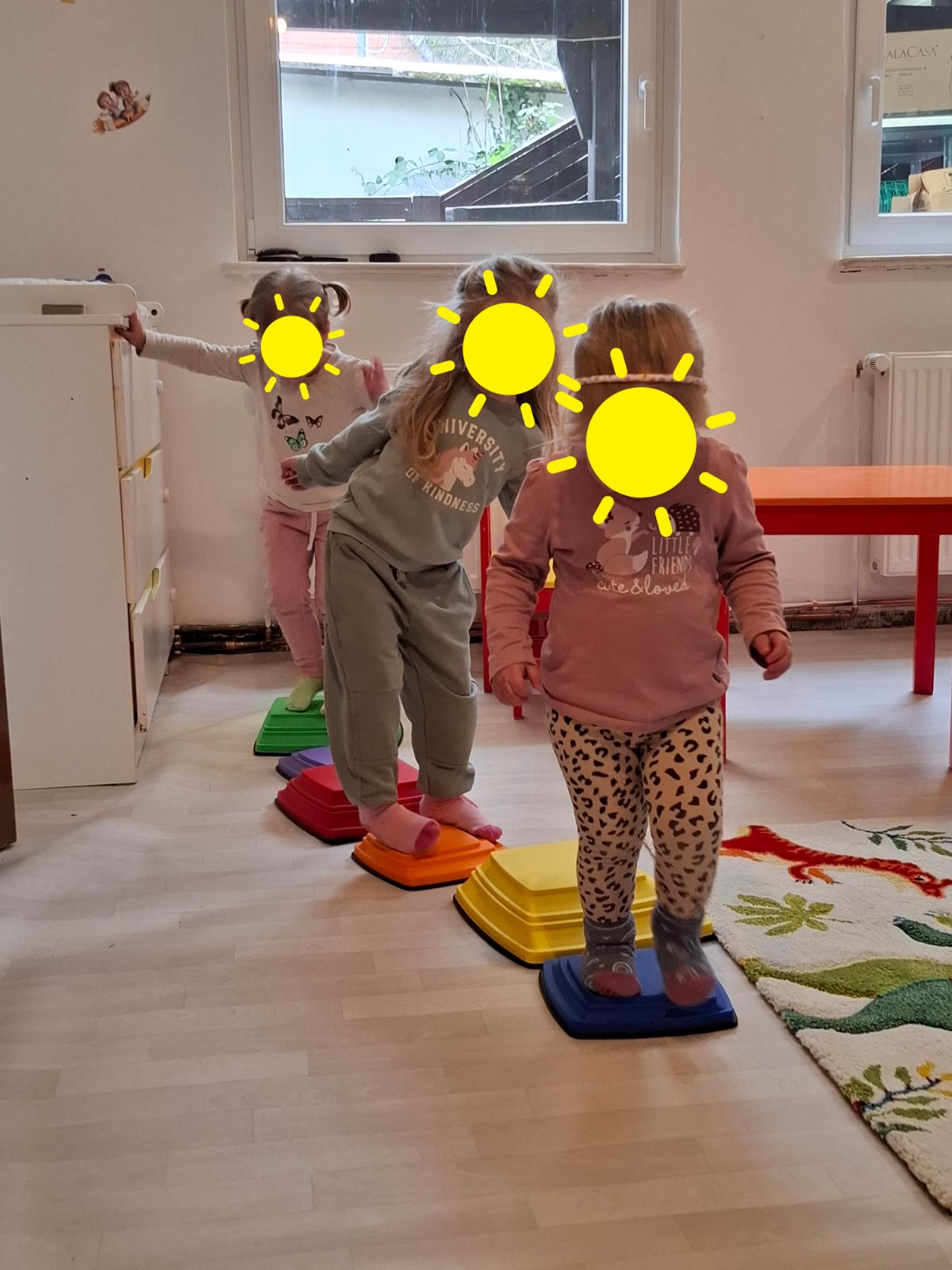Kinder balancieren auf bunten Stapelsteinen
