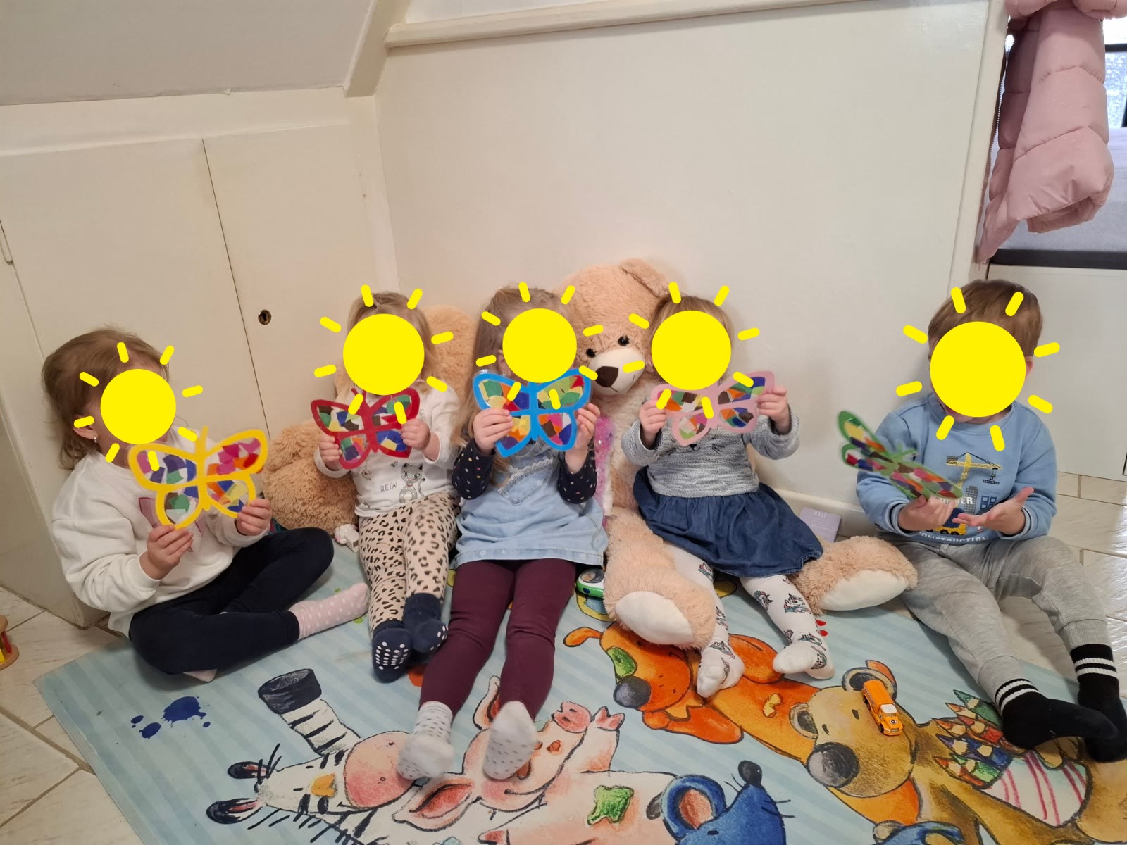 Kinder zeigen bunte gebastelte Schmetterlinge