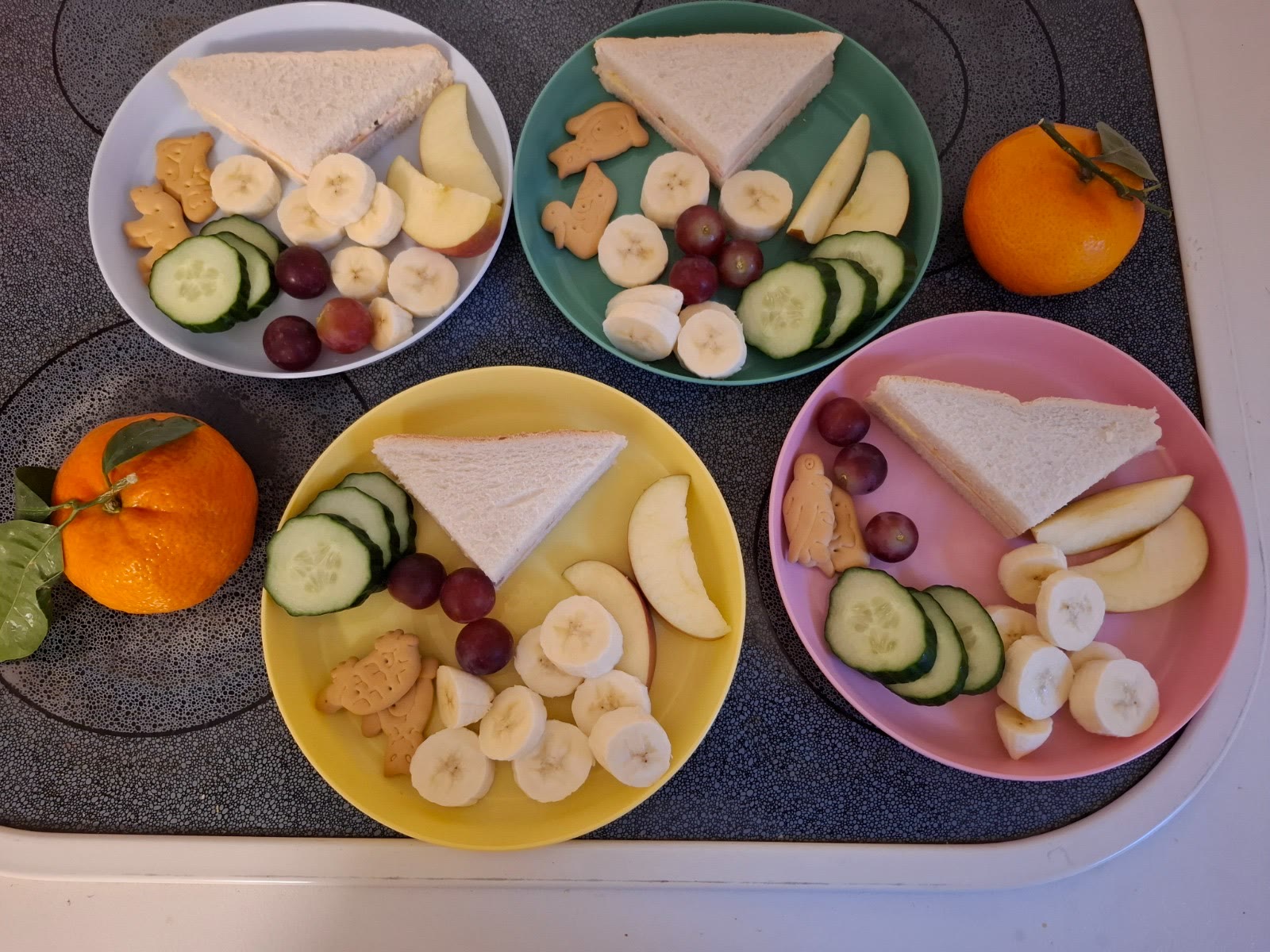 Vorbereitete Teller mit Obst, Gemüse und kleinen Sandwiches zum Frühstück