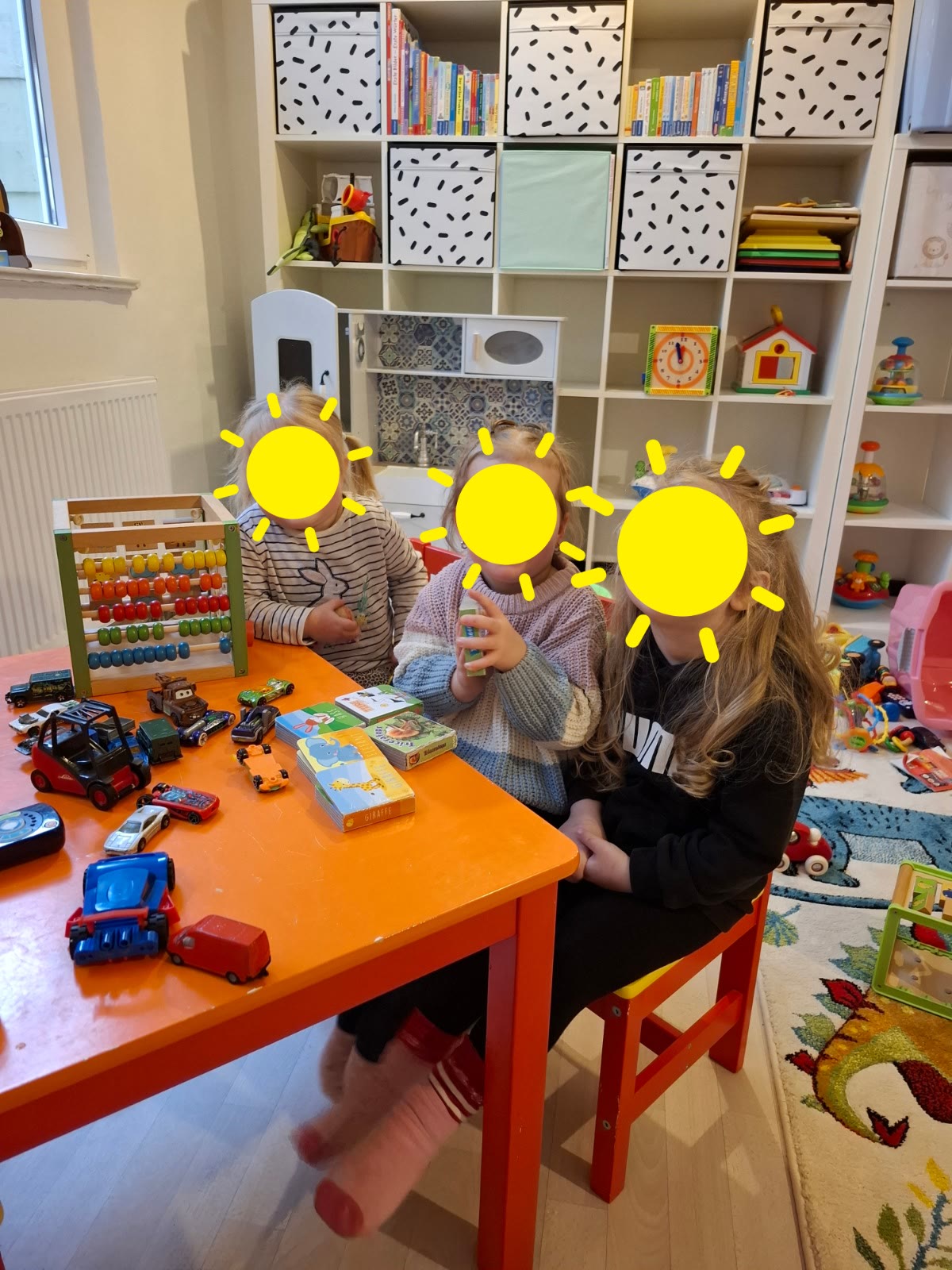 Kinder spielen gemeinsam im Gruppenraum am Tisch