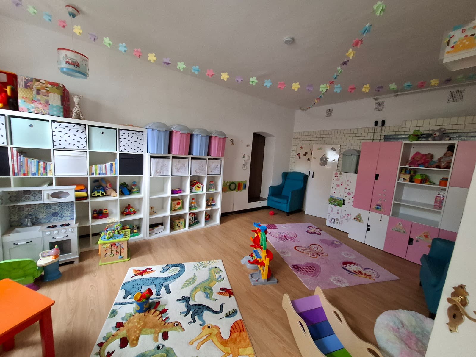 Großes Spielzimmer mit Regalen, Teppichen und viel freier Fläche
